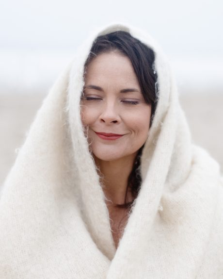 woman, snuggled with a blanket outdoors