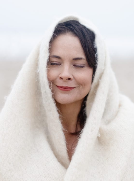 woman, snuggled with a blanket outdoors